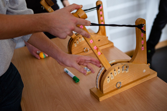Ein Holzkatapult das gespannt wird.