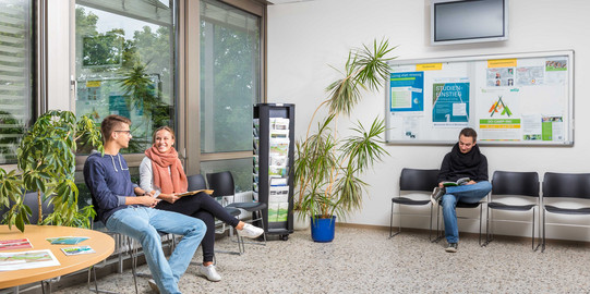 Studierende sitzen im Wartebereich der Studienberatung